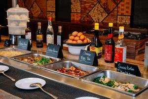 a buffet with two trays of food and bottles of wine at SHANKEE Sudirman in Jakarta
