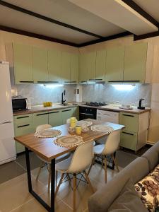 a kitchen with a table and chairs in a kitchen at Leonovs in Almaty