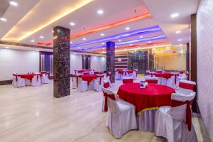 a banquet hall with red and white tables and chairs at Hotel Downtown by Quadis - East of Kailash in New Delhi