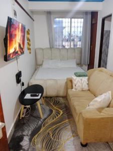 un salon avec un canapé et un lit dans l'établissement Haven's spot, à Mombasa