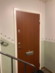 uma porta de madeira num quarto com uma escada em Privat room with 160 bed near Arlanda Airport em Märsta