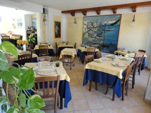 a restaurant with tables and chairs and a painting on the wall at Hotel Silvestrino in Stintino
