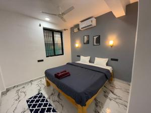 Un dormitorio con una cama con un edredón azul. en Village Harmony Guest House, en Canacona