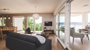 un salon avec un canapé et une salle à manger dans l'établissement Luxury Villa Mihaela beachfront by Villas Guide, à Jadranovo