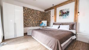 une chambre avec un grand lit et un mur en pierre dans l'établissement Luxury Villa Mihaela beachfront by Villas Guide, à Jadranovo 51 autres photos
