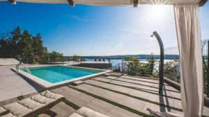 une piscine avec vue sur l'eau dans l'établissement Luxury Villa Mihaela beachfront by Villas Guide, à Jadranovo
