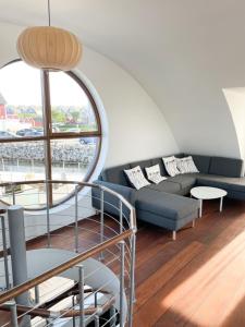 een woonkamer met een bank en een groot raam bij 5-star houseboat of 125 m2 with its own bathing jetty in Nykøbing Sjælland