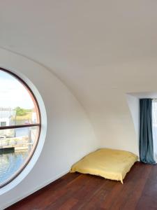een bed in een kamer met een raam bij 5-star houseboat of 125 m2 with its own bathing jetty in Nykøbing Sjælland