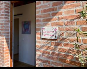 un panneau sur le côté d'un mur de briques dans l'établissement L'Albero di Gamelì Apartments, à Chiusi