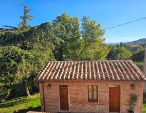 une petite maison en briques avec un toit en carrelage dans l'établissement L'Albero di Gamelì Apartments, à Chiusi