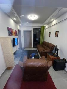 een woonkamer met een bank en een tv bij Sky Vista Homes in Nairobi