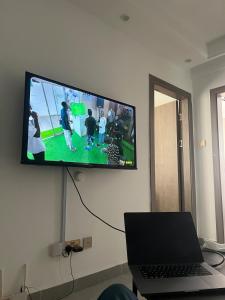 een televisie aan de muur met een laptop bij Sky Vista Homes in Nairobi
