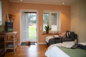 Un dormitorio con una cama y un sofá y una ventana. en Charming Lahemaa national park Studio apartment for Nature Lovers, en Kolga