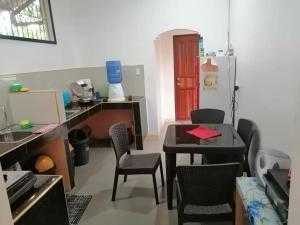 Zimmer mit einem Tisch, Stühlen und einem Kühlschrank in der Unterkunft J and J Residence in General Luna + 4 Fotos