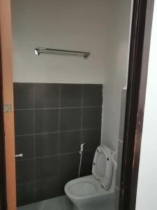 ein Badezimmer mit einer Toilette mit hochgeklapptem Sitz in der Unterkunft J and J Residence in General Luna