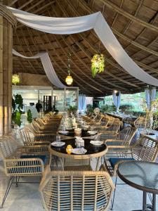 un ristorante con tavoli e sedie e un grande soffitto di Triple Dreams Resort  Altre 37 foto