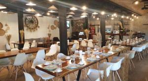 a large room with a long table and white chairs at River Kwai Village Hotel in Ban Kaeng Raboet