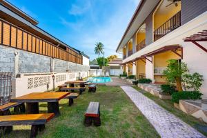 a courtyard with benches and a swimming pool at Chernin Apartment Suites, Rawai in Ban Saiyuan (1) +30 photos