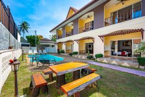 a house with a ping pong table in the yard at Chernin Apartment Suites, Rawai in Ban Saiyuan (1)