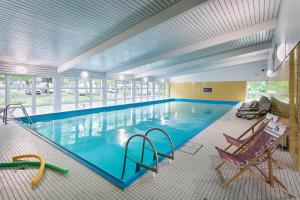 a large swimming pool with two chairs at KNAUS Campingpark Walkenried in Walkenried