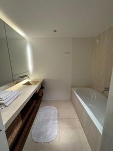 a bathroom with a sink and a tub and a mirror at Apartment Chalet Ambros in Lech am Arlberg +8 photos