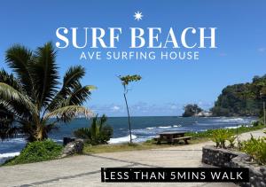 a view of a beach with a bench and the ocean at Ave Surfing House in Mahina