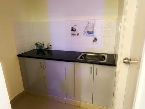 a kitchen with white cabinets and a sink at Hotel SAFKO Grand - Hopefarm Metro Whitefield in Bangalore