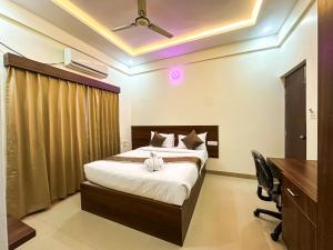 a hotel room with a bed and a desk and a desk at Hotel SAFKO Grand - Hopefarm Metro Whitefield in Bangalore +28 photos