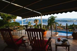 a patio with chairs and tables and a view of the water at Sicily in Villa in Messina