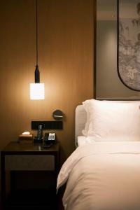 北京市にあるThe Purple Horse Hotel Beijingのベッドと電話付きのテーブルがある寝室 +181枚の写真