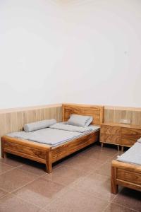 een houten bed met 2 kussens in een kamer bij Baviecoresort in Ba Vì +22 foto's