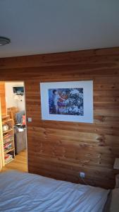 a bed with a wooden headboard with a picture on it at Les Isards Pied des pistes in Ax-les-Thermes