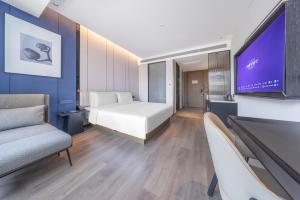 una camera d'albergo con un letto e una TV a schermo piatto di Mercure Jinan Beiyuan Street a Jinan
