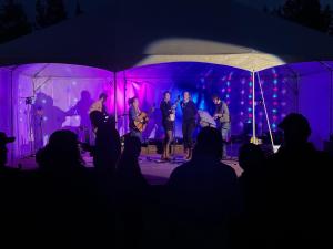 a group of people on a stage in a tent at McCarthy Lodge Resort in McCarthy