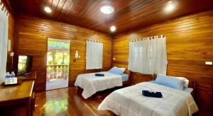 Un dormitorio con dos camas y un televisor. en Phuphan Park Hotel, en Ban Si Wicha