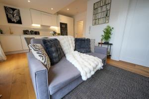 a living room with a gray couch with pillows at The Sea Pearl in Eastbourne