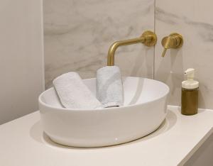 ein weißes Waschbecken mit einem Wasserhahn und zwei Handtüchern in der Unterkunft The Sea Pearl in Eastbourne + 11 Fotos