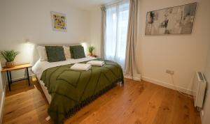 ein Schlafzimmer mit einem Bett mit einer grünen Decke in der Unterkunft The Sea Pearl in Eastbourne