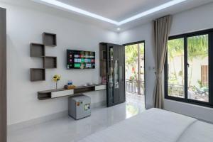 Habitación blanca con cama y ventana grande. en Globiquex hotels, Phu quoc, en Phu Quoc