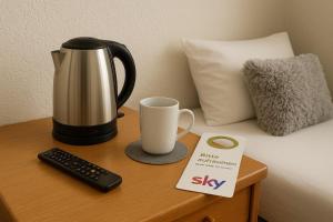 a coffee maker and a cup on a table at Hotel Nassauer Hof Frankfurt - Nähe Jahrhunderthalle Süwag Energie Arena in Frankfurt/Main