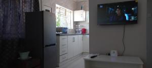 eine Küche mit einem Flachbild-TV an der Wand in der Unterkunft Ps House in Gaborone
