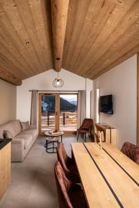 a living room with a wooden ceiling and a table at Chalet Valora in Le Grand-Bornand