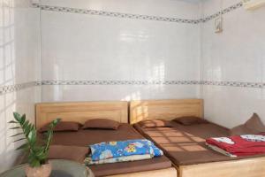 ein Schlafzimmer mit 2 Betten und einer Topfpflanze in der Unterkunft Vườn Dừa Cam Bình 1 in La Gi