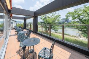 姫路市にあるコンフォートイン姫路夢前橋のテーブルと椅子付きのバルコニーから川の景色を望めます。