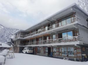 a large building with snow on the ground at Cedar Valley Retreat in Jagatsukh +18 photos