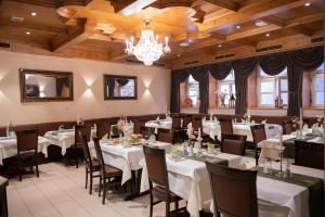 a dining room with tables and chairs and a chandelier at Hotel Zu den Drei Kronen in Seligenstadt