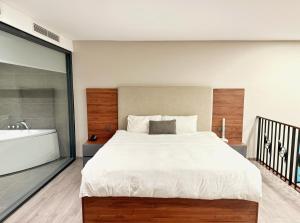 a bedroom with a large bed and a bath tub at PentStudio Westlake - Cozy Duplex Apartment in Hanoi +5 photos