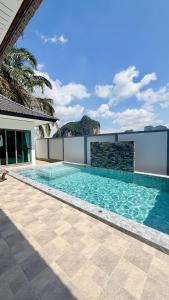 a swimming pool on the side of a house at Legacy pool villa in Ban Chong Phli