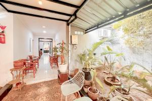 a room with a bunch of plants and chairs at Perdana Kasih Hotel Pemuda Klaten Mitra RedDoorz in Solo