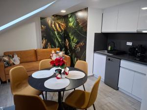 Una cocina y una sala de estar con mesa y sillas. en ÚJ - Emili Apartman Miskolctapolca - 27 főre, en Miskolctapolca